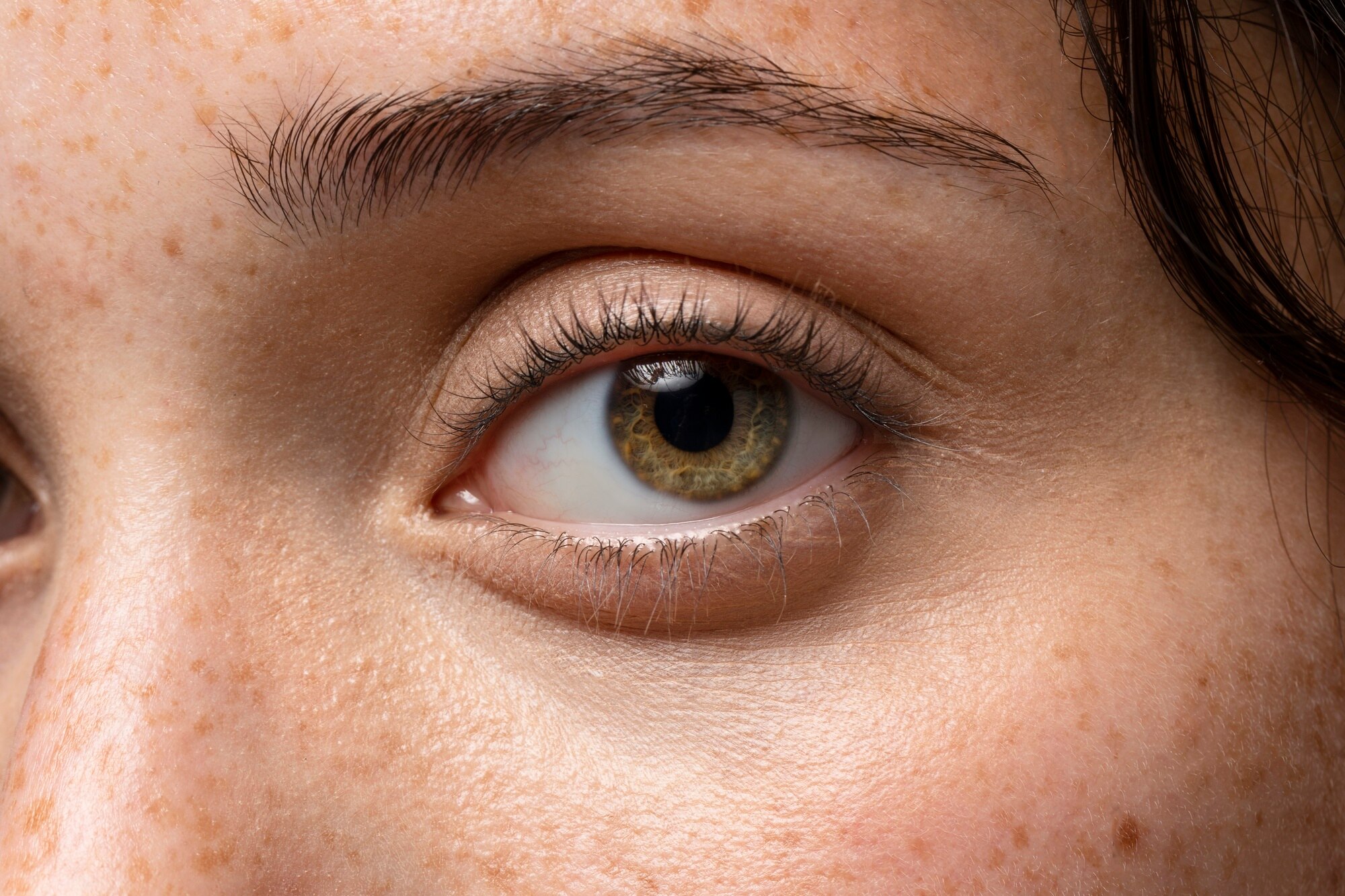 Primer plano de un ojo humano color marrón, mostrando el iris con detalle