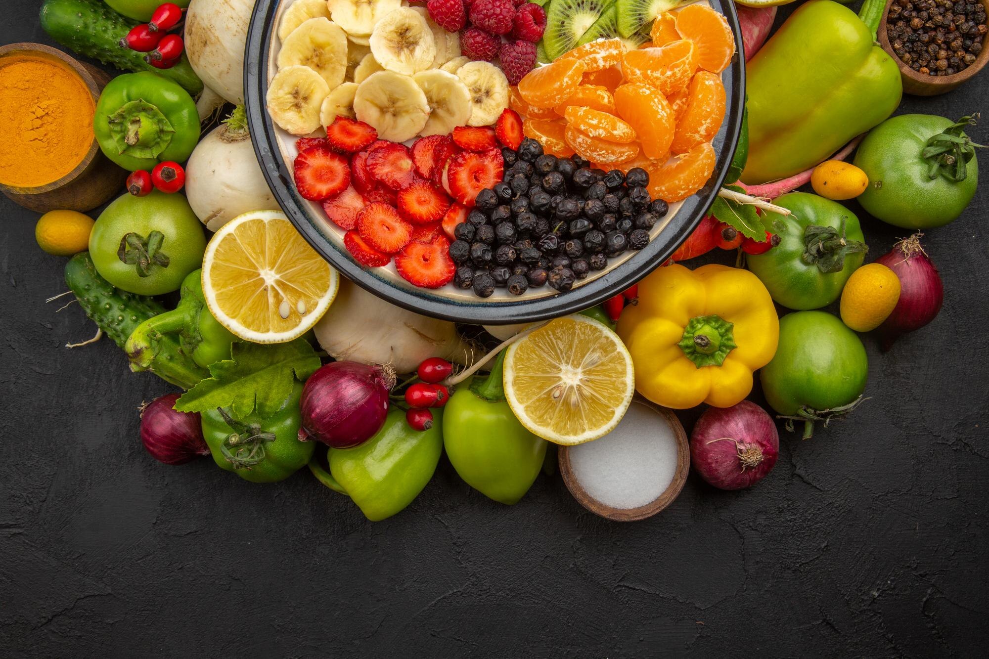 Mesa con una variedad de frutas y verduras frescas de distintos colores